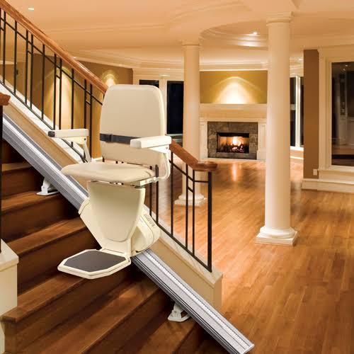 Harmar SL600 Pinnacle stairlift parked mid-staircase in a finished home with a stone fireplace in the background